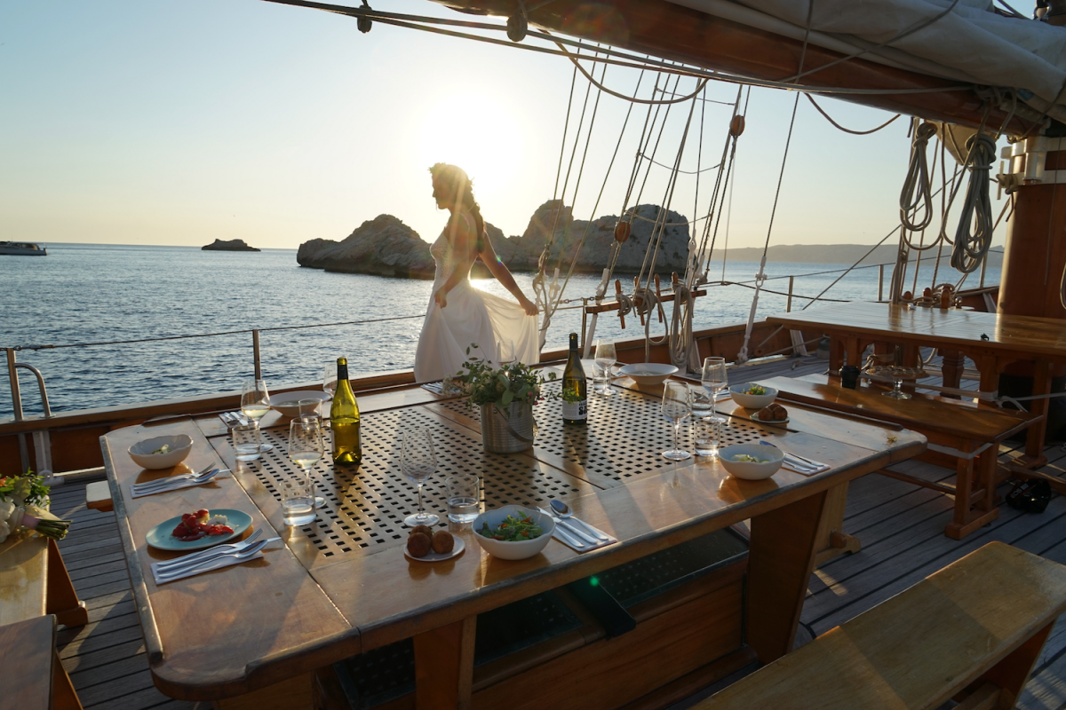 Repas servi sur la table du voiler en pleine mer avec une femme en arrière plan