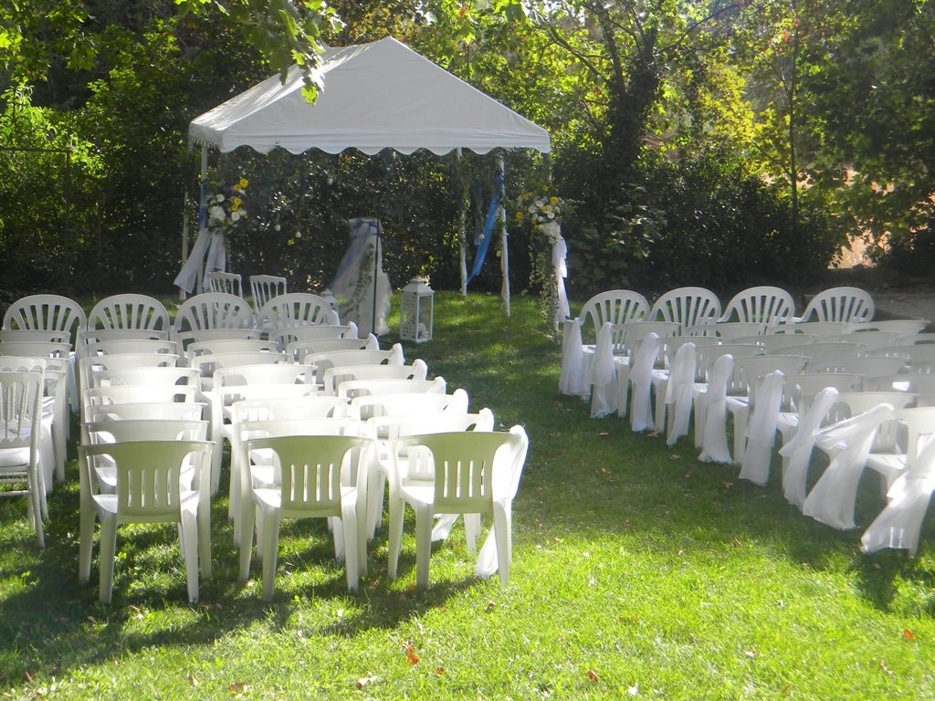 Installation de chaises blanches pour cérémonie et petit chapiteau